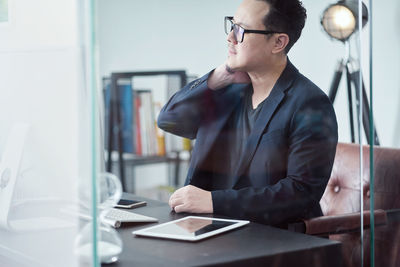 Businessman with neck pain sitting on table