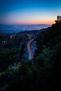 Traffic winds through the curves of mt. lemmon with the city of tucson in the fading twilight below.