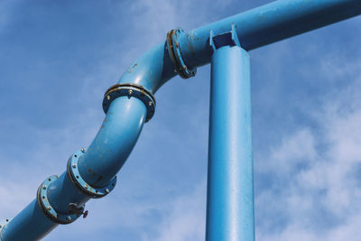 Low angle view of metallic pipe against sky