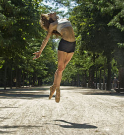 Ballerina pose jumping outdoors, lifestyle concept.