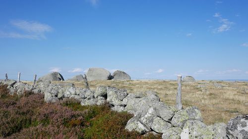 Rock formations on landscape against blue sky