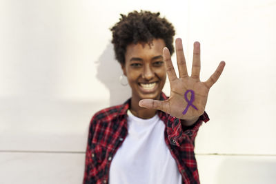 Portrait of smiling boy standing against wall