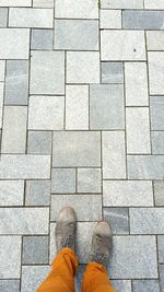 Low section of man standing on tiled floor