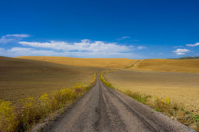 Empty road along countryside landscape