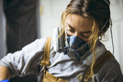 Female resin artist mixing with respirator mask