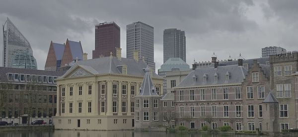 Buildings in city against cloudy sky