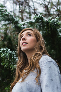 Close-up of young woman against trees