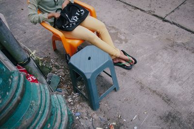 Low section of young woman sitting outdoors