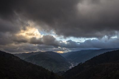 Scenic view of mountains against cloudy sky