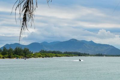 Scenic view of sea and mountains against sky