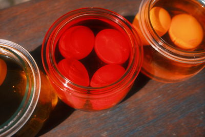 High angle view of colored eggs in bottles on table