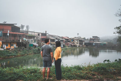 Rear view of people on lake against clear sky