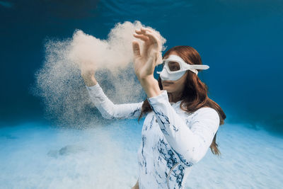 Portrait of young woman standing against sea