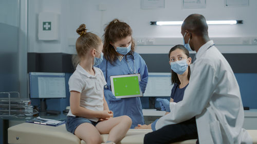 Female doctor examining patient in office