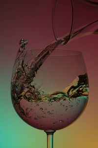 Close-up of water splashing in glass against gray background