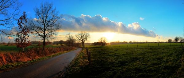 Scenic view of grassy field against cloudy sky