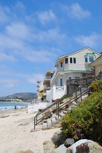 Built structure on beach by buildings against sky