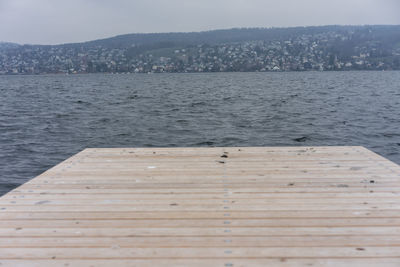 Pier over sea against sky in city