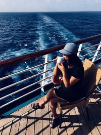 Woman drinking coffee while sailing in sea