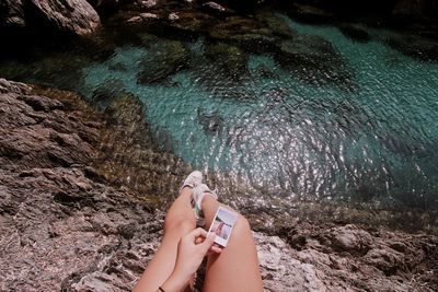 Low section of woman sitting over sea