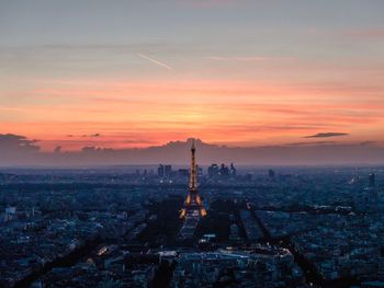 Aerial view of buildings in city during sunset