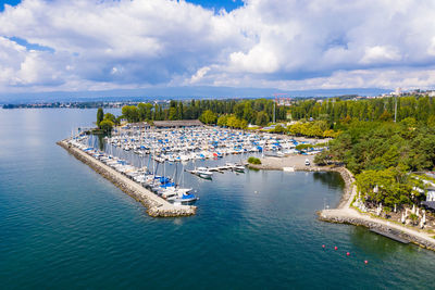 Boats moored in harbor against sky