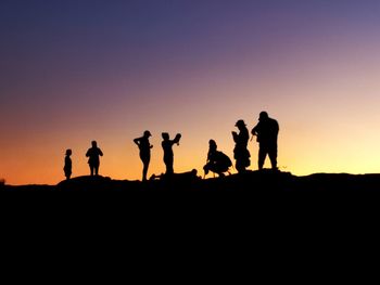 Silhouette people standing against clear sky during sunset