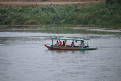 People in boat sailing on river