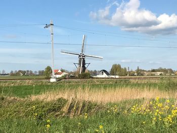 Traditional windmill on field against sky