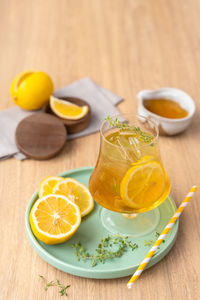 Lemonade iced tea cocktail with lime lemon sliced on the wooden table.