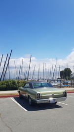 Sailboats in city against blue sky