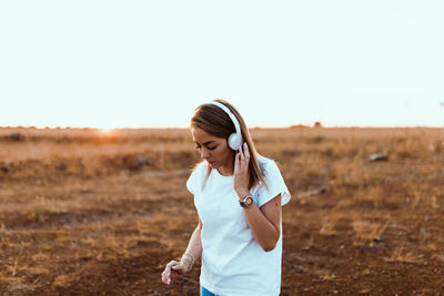 Woman standing on field against clear sky