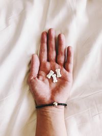 High angle view of human hand on bed