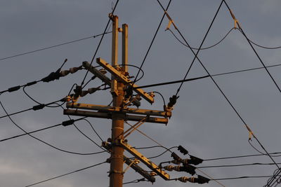 Low angle view of electricity pylon against sky