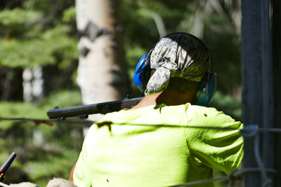 Rear view of man shooting gun