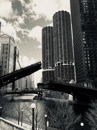 Low angle view of bridge and buildings against sky