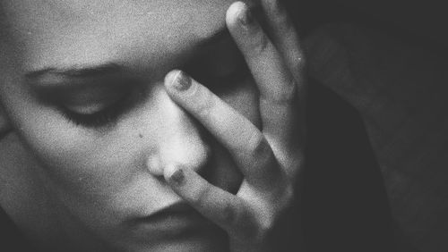 Close-up of depressed young woman with hand on face