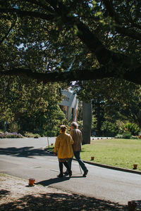 Rear view of people walking on street in city