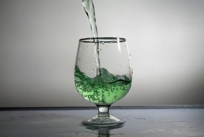 Close-up of wineglass on table against white background