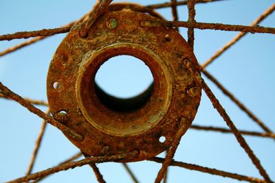 Low angle view of rusty metal against sky