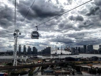 Overhead cable cars in city against sky