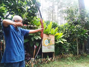 Rear view of man standing by plants