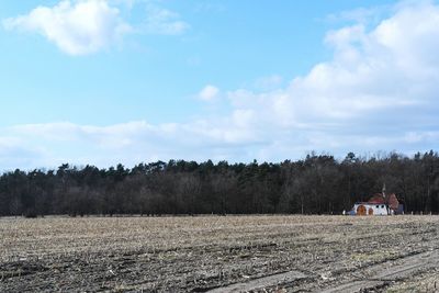 Scenic view of field against cloudy sky