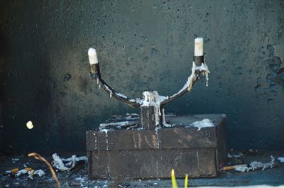 Close-up of candle holder against a wall