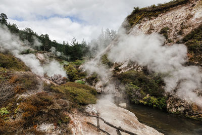 Smoke emitting from volcanic geyser against sky