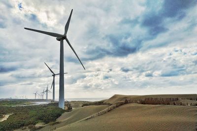 Windmill on field against sky