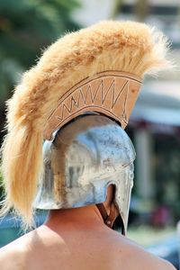 Rear view of shirtless man wearing knight helmet during event