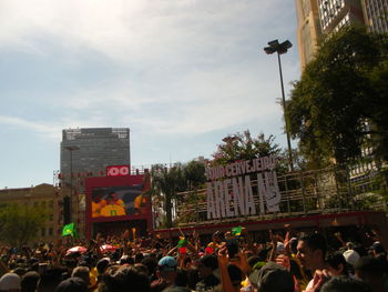 People on street in city against sky