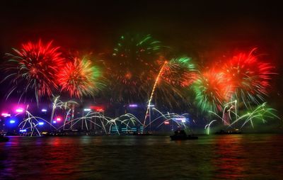 Low angle view of firework display in city at night