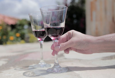 Cropped image of man holding wineglass at table